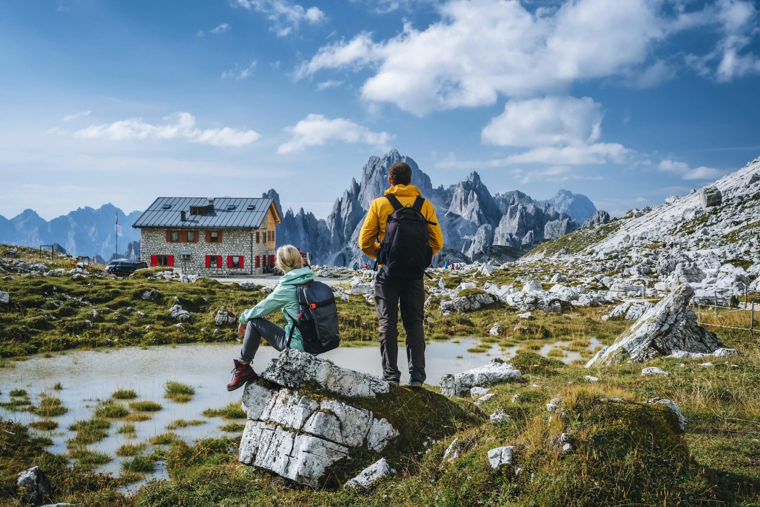 Couple in Dolomites. Rifugio Lavaredo with Cadini di Misurina mountain group in background. Italy